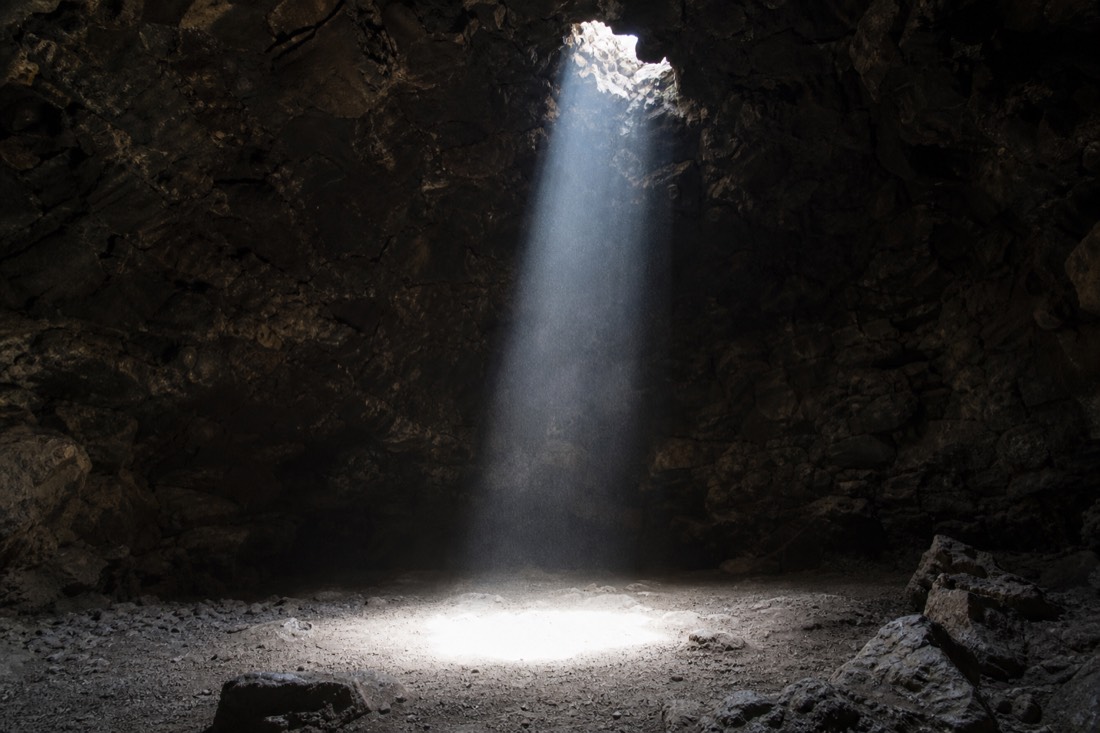 A shaft of daylight falling through the natural opening in the roof of the lava cave restaurant