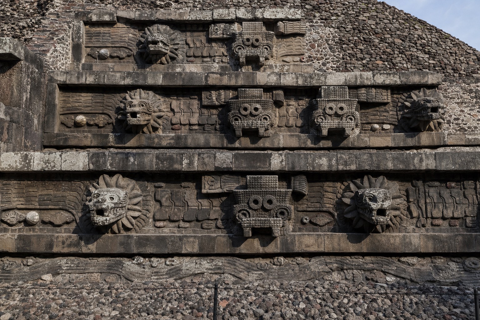 The Temple of the Feathered Serpent at Teotihuacan with rows of carved stone serpent heads on its facade