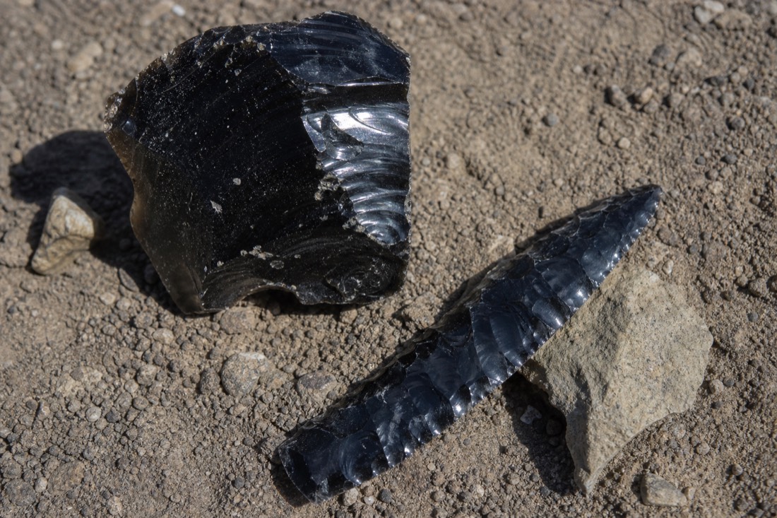 Raw black obsidian beside a knapped blade, the volcanic glass that made Teotihuacan wealthy