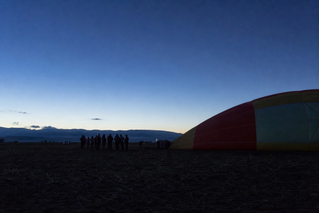 Passengers waiting in the dark on a launch field before a Teotihuacan balloon flight