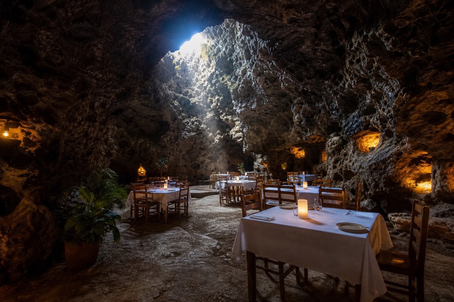 Candlelit tables set inside a natural volcanic cave restaurant near the Teotihuacan pyramids
